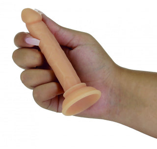 En hand håller i Addiction Dildo Med Sugpropp - 12 cm, en köttfärgad dildo med realistiska detaljer och en sugkoppsbas för mångsidig användning.