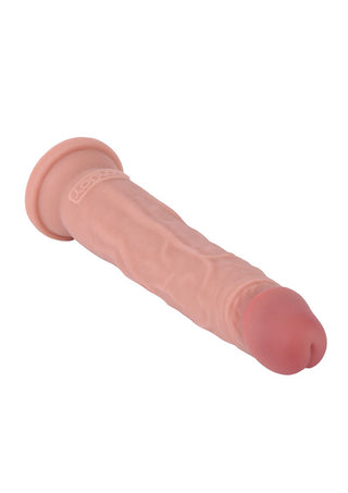 Deluxe Dual Density Dildo har en realistisk, kötttonad design med en strukturerad yta och rundad spets. Dess utsvängda bas och synliga vendetaljer ger en autentisk hudkänsla, allt presenterat mot en skarp vit bakgrund.