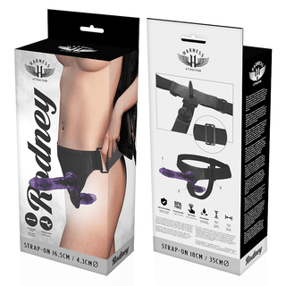 Harness - Dubbel Strap-On Med Vibrationer" har förpackningar som visar produktdimensioner och inkluderar en detaljerad illustration på kartongen för dess justerbara lila strap-on.