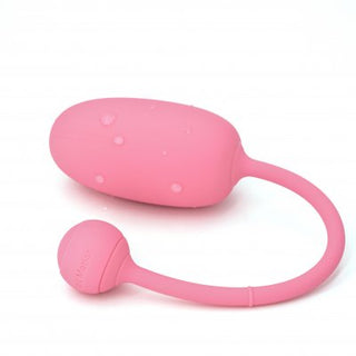 Upptäck Magic Motion Kegeltränare Rosa, en rosa trådlös och vattentät personlig massageapparat med fjärrkontrollfunktioner för optimal avkoppling, med en lugnande yta som glittrar av vattendroppar.