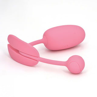 Magic Motion Kegeltränare Rosa är en rosa bärbar vibrerande leksak med en fjärrkontroll på vit bakgrund, perfekt för att förbättra din Kegelövningar-upplevelse.