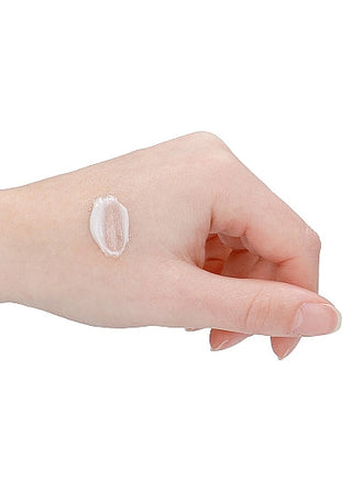 En hand med ljus hud visar en liten mängd av den krämiga texturerade Milt Bedövande Anal Gel, en lugnande bedövande kräm.