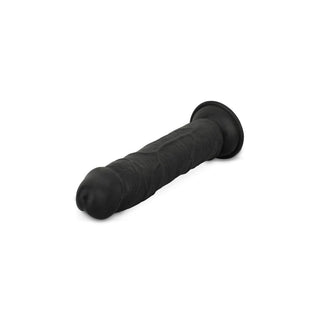 Dildo utan bollar, tillverkad i svart silikon, erbjuder en realistisk struktur och en robust sugbas, elegant utställd mot en vit bakgrund.