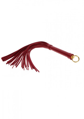 TabooM Flogger - Bondage är ett rött nöjesverktyg med ett läderhandtag och flera tofsar, framhävda av en guldring. Den är perfekt för dem som gräver ner sig i bondage-produkter och lägger till elegans till alla kollektioner.