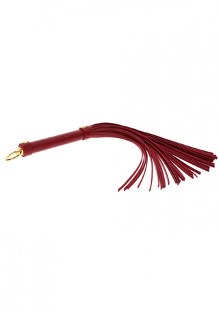 TabooM Flogger - Bondage är en lyxig röd piska med flera tofsar och en guldklämma på handtaget, perfekt för att utforska bondageprodukter.