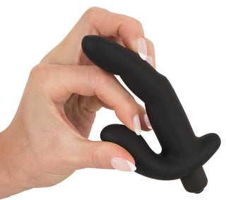 En hand håller den snygga, svarta "Prostata / G-punkt Vibrator - 13 cm" med en böjd design, perfekt för att förhöja njutningen.
