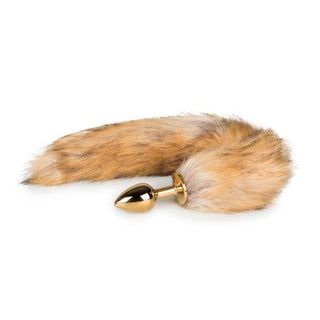 EasyToys Buttplug Med Svans - Liten är en buttplug i guld som är idealisk för djurleksentusiaster, med en fluffig brun och vit fuskpälssvans mot en orörd vit bakgrund.