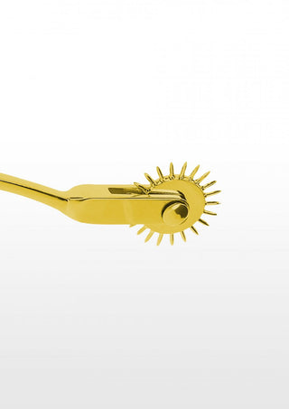 Mot en orörd vit bakgrund glittrar Guld Pinwheel 1-Hjul lockande. Detta gyllene BDSM-verktyg har ett spikhjul designat för att väcka sinnena och väcka nyfikenhet.