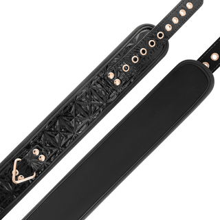 Närbild av två svarta BegMe Halsband Med Koppel-remmar i veganskt läder, med metallöglor och roséguldaccenter. En rem har en strukturerad design med en triangulär metallklämma, medan den andra är slät, båda tillverkade med nickelfri metall för en allergenfri upplevelse.