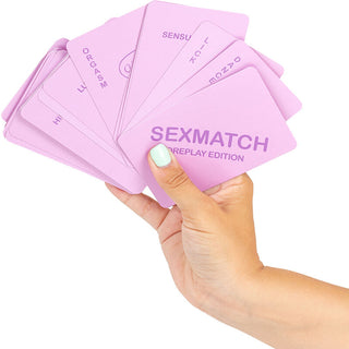 En hand håller en utbredd kortlek med rosa SexMatch Förspelsspel för Par-kort, det perfekta kortspelet för par som vill piffa till intima stunder.