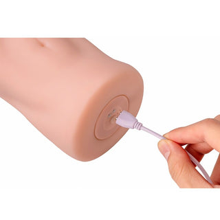 Xise Elaine Vagina Masturbator i mjuk silikon, visad med laddningskabel på en vit bakgrund.