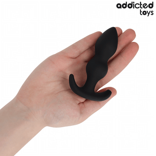 Analplugg i svart silikon, 10 cm lång med böjd bas och Addicted Toys-logotypen i hörnet.