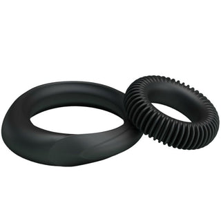 Två svarta penisringar av silikon: en slät, avsmalnande ring och en mindre, räfflad ring.