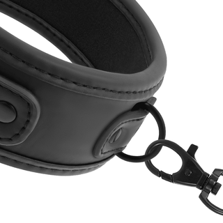 Närbild av en svart Veganskt läder-rem med synliga sömmar och knappdetaljer, med en metallkrok fäst vid en cirkulär ring. De polerade metalldelarna kontrasterar mot den vita bakgrunden och antyder dess användning som Fetish Neoprene Halsband & Koppel BDSM-tillbehör.