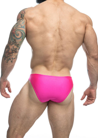 En tatuerad man poserar bakifrån i rosa trosor och framhäver Classic Herr Badbyxa med sin bekväma och hållbara passform mot en vanlig vit bakgrund.