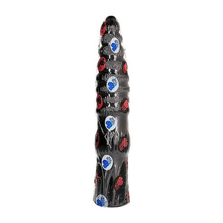 Ett högt, räfflat, svart föremål prydt med blå och röda cirkulära klistermärken liknar en All Black Analdildo.