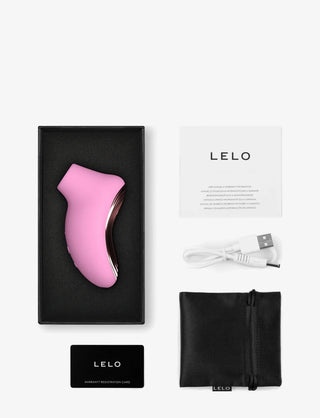 LELO SONA 2 Travel rosa klitorisstimulator med SenSonic-teknik, USB-laddare, instruktioner, garantikort och svart förvaringsväska som visas på en vit bakgrund.