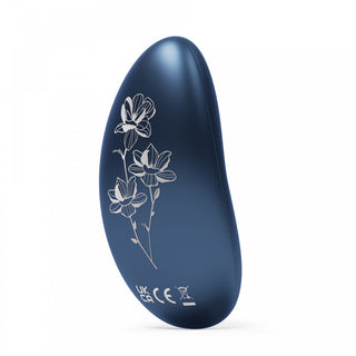 LELO Nea 3 är ett elegant, böjt föremål i blått med en minimalistisk design och ett elegant vitt blommönster på sidan, med certifieringsmärkningar och en förenklad estetik.
