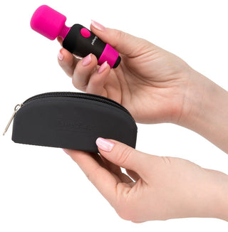 Palm Power Pocket Wand, med sitt flexibla huvud, hålls ovanför ett elegant svart fodral med dragkedja.