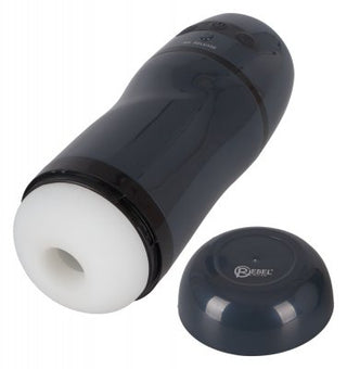 En mörkfärgad cylindrisk Masturbator - Sugande Effekt - Rebel med en vit öppning sitter bredvid ett löstagbart lock, som påminner om en elegant modern vibrator.