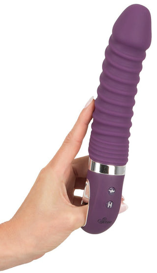 En hand håller Vibrerande dildo med värmefunktion, en lila ribbad vibrator gjord av flytande silikon med handtagskontrollknappar och 12 vibrationslägen för personlig njutning.