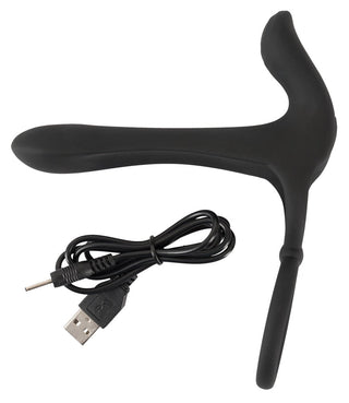 Penisring Couples Vibrator, en ergonomisk svart enhet med en klitorisstimulator, inkluderar en USB-laddningskabel och visas på en orörd vit bakgrund.