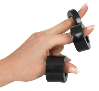 En hand med välskötta naglar balanserar elegant tre svarta ringar från Rebel MBS Ball Stretching Kit på fingrarna.