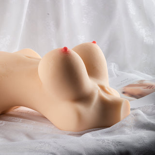 Onanihjälpmedel XXL, hudfärgat silikon, 10,9 kg, med motiv av stora bröst på vit spetsbakgrund.