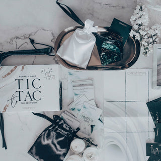 Elegant placerad på en marmoryta med chica förpackningar och blommor, "Tic Tac To The Bedroom Premium" är perfekt för dig som söker lekfulla förspelsaktiviteter och kryddiga frågor för att piffa till kvällen.