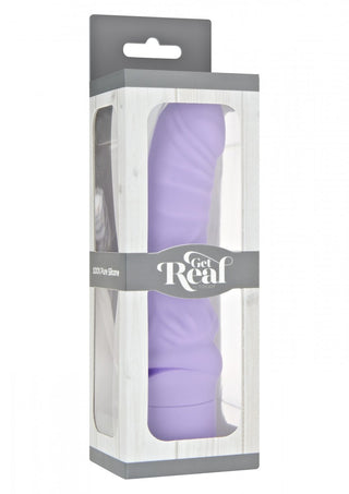 En förpackad lila Get Real Mini Dildovibrator i silikon står upprätt i sin förpackning, som har en grå och vit design och ett genomskinligt fönster.