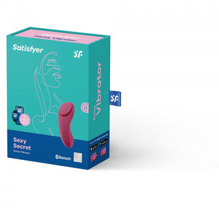 Turkos box visar Satisfyer Sexy Secret Trosvibrator, med streckteckningar och produktdetaljer. Den inkluderar en trådlös fjärrkontroll för diskret nöje och sömlös kontroll över din upplevelse.