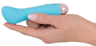 En hand håller den kompakta Cuties Mini-vibratorn 13 cm med en slät, rundad design och flera vibrationslägen för personlig njutning.