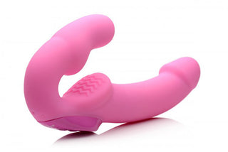 Strap-On Med Fjärrkontroll - 24 cm har en rosa, böjd silikondesign med dubbla ändar, som liknar en strap-on vibrator för intim användning, mot en vit bakgrund.