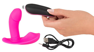 Panty Vibrator i rosa är gjord av kroppssäkert silikon och inkluderar en snygg svart fjärrkontroll plus en USB-laddningskabel, ställd mot en vit bakgrund.