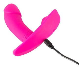 Den rosa trosvibratorn, tillverkad av kroppssäkert silikon, har en böjd design och visas med en ansluten laddningskabel.