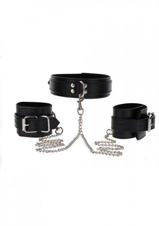 Halsband & Handbojor TabooM-setet har svart läderimitationskrage och handledsmanschetter sammanlänkade med silverkedjor, som visas på en vit bakgrund, perfekt för ett utsökt bondage-kit.