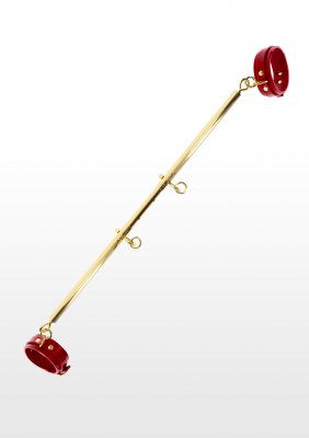TabooM Spreadbar, en elegant guldmetall-spreadbar med djärva röda manschetter, är elegant uppvisad mot en orörd vit bakgrund, vilket gör den till det perfekta sofistikerade tillägget till din BDSM leksak-kollektion.