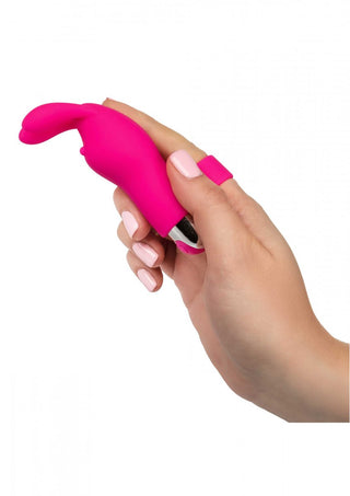 En hand håller Fingervibrator Med Öron - Rabbit, en kompakt rosa vibrator med en unik kaninöra-design, idealisk för diskret och riktad njutning.