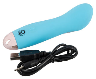Cuties Mini vibrator 13 cm i blått visas bredvid en svart USB-laddningskabel på en vit bakgrund, och erbjuder flera vibrationslägen för en personlig upplevelse.