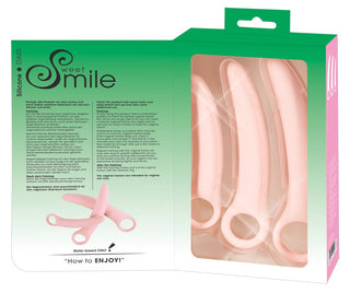 Den gröna lådan innehåller Vaginal Trainers Set, som innehåller tre rosa personliga massageapparater i silikon. Förpackningen innehåller användningsinstruktioner och produktdetaljer.