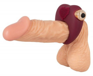 En realistisk fallisk dildo med en rödbrun Röd Vibrerande Cockring säkrad nära basen.