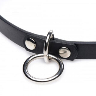 Vixen Choker Med O-Ring är ett justerbart svart läderstycke med metalldubbar och en central cirkulär ring, perfekt för att lägga till en edgy touch till din stil.