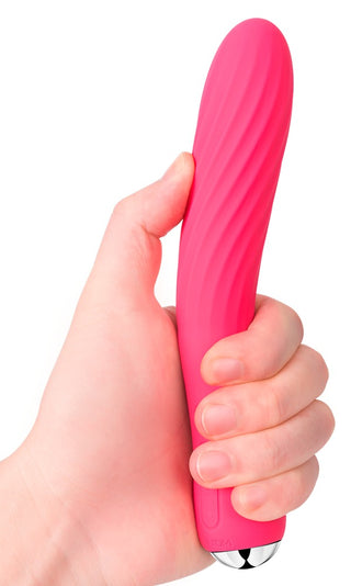 En hand håller Svakom Anya Värmande Vibrator, en rosa, strukturerad cylinder med metallbas och silikonräfflor.