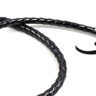 Närbild av en svart flätad läderpiska mot en vit bakgrund, liknande Lack Bullwhip.