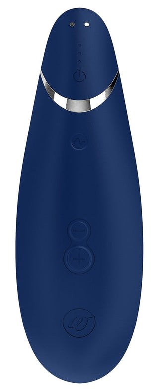 Womanizer Premium 2 är en blå, handhållen enhet med en slät, långsträckt form och silverdetaljer nära toppen. Den har flera framåtvända cirkulära knappar och är förbättrad med Pleasure Air™-teknik för en exceptionell upplevelse.